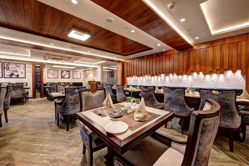 a restaurant with wooden walls and tables and chairs at Best Western Plus Revanta Mcleod Ganj in Dharamshala