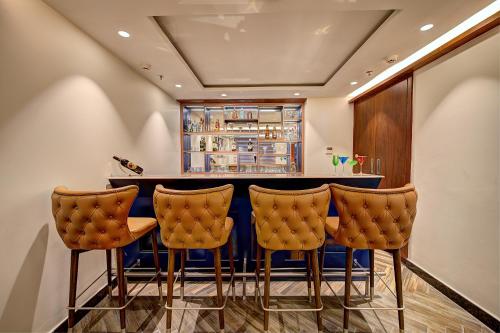 a bar with yellow chairs and a blue counter at Best Western Plus Revanta Mcleod Ganj in Dharamshala