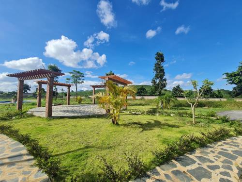 un parc avec deux kiosques et des palmiers dans l'établissement Emopea Moc Chau, à Mộc Châu
