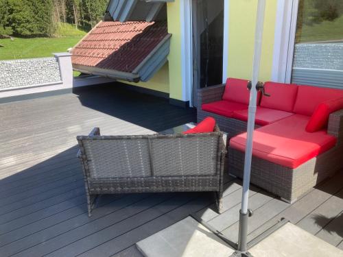 a patio with a couch and an umbrella on a house at Ferienwohnung Wittenburg in Hermagor