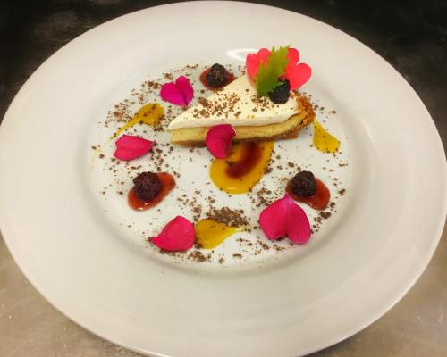 a white plate with a dessert with flowers on it at Penzion U Broucka in Milevsko