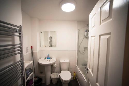 a bathroom with a toilet and a sink and a shower at A Cosy 3-bed Family House in Liverpool sleeps 6 with parking spaces in Liverpool