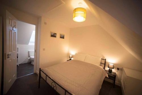 a bedroom with a bed with a light on it at A Cosy 3-bed Family House in Liverpool sleeps 6 with parking spaces in Liverpool