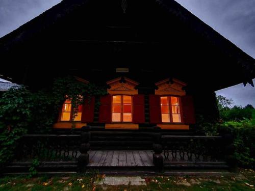 a small house with red windows and a porch at Alexandrowka Wohnen im UNESCO Weltkulturerbe Haus in Potsdam
