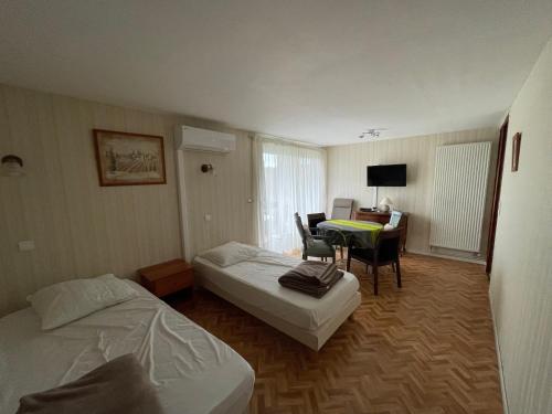 a hotel room with two beds and a table and a desk at Résidence Les Milandes in Cazaubon