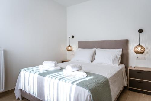 a bedroom with a large bed with two towels on it at Amelia Luxury Living in Volos