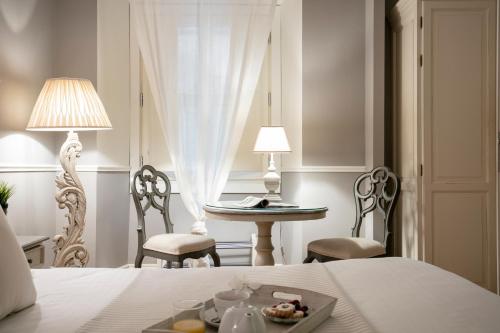 una camera con un letto, un tavolo e sedie di B&B Emozioni Fiorentine a Firenze
