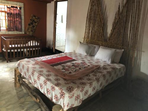 1 dormitorio con 1 cama con cabecero de madera en Kivu Beach Garden, en Gisenyi