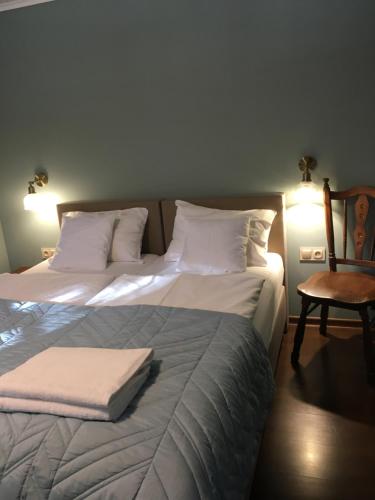 two beds in a room with a chair and lights at Decor Park Apartament in Karpacz