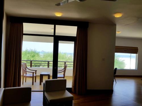 a living room with a table and chairs and a balcony at Nilaveli Beach Hotel in Nilaveli