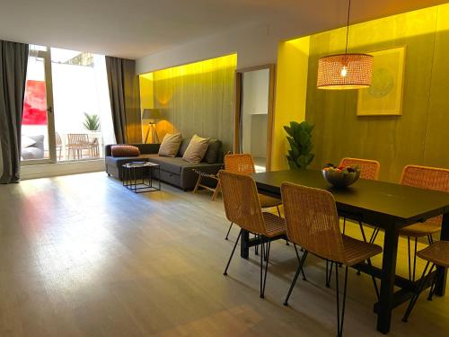 a living room with a table and chairs and a couch at Moontels Paseo de Ruzafa in Valencia