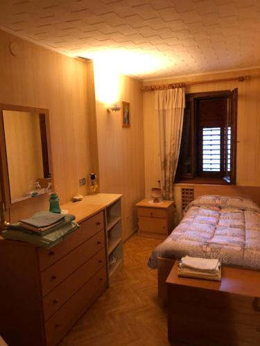 - une chambre avec un lit, une commode et un miroir dans l'établissement Casa in valle, à Sicina