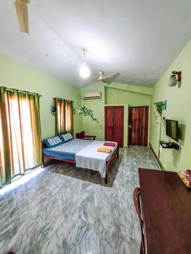 a bedroom with a bed and a tv in it at Auslyn Guest House in Bogmolo