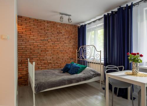 een kamer met een bakstenen muur en een bed en een tafel bij Apartament Fifi in Warschau
