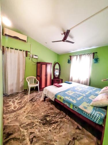 a bedroom with a bed and a ceiling fan at Auslyn Guest House in Bogmolo