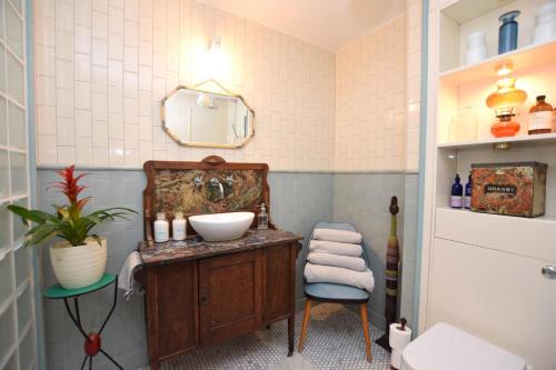 a bathroom with a sink and a mirror and a chair at Stylish 3 bed house with parking in Bermondsey, SE1 in London