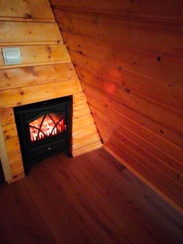 a room with a fireplace in a wooden room at Popasul Dacilor in Predeluţ