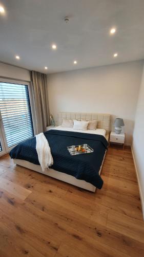 a bedroom with a large bed and a wooden floor at Ella's Lounge - besonders genießen in Singen