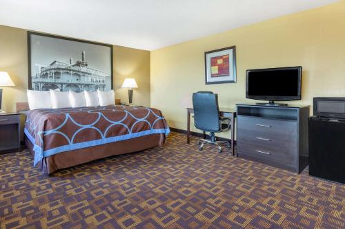 a hotel room with a bed and a flat screen tv at Super 8 by Wyndham Decorah in Decorah