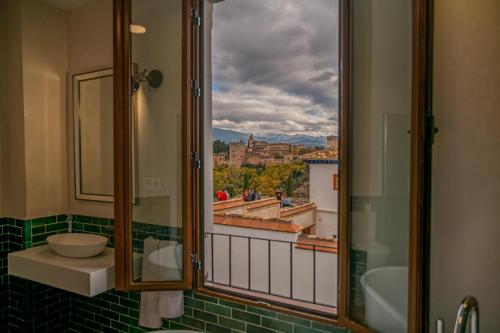 baño con ventana con vistas a la ciudad en Florentia San Nicolás, en Granada
