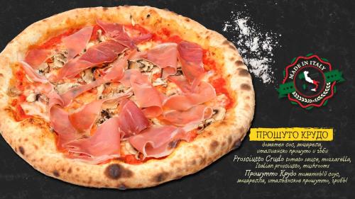 a pizza with ham on it on a table at Sea Horse in Burgas City