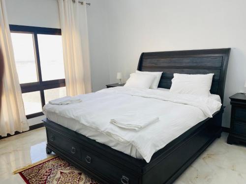 a bedroom with a large bed with white sheets at Alhama Hotel Appartment in Khasab