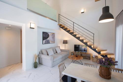 a living room with a couch and a staircase at Grappolo Lefkada Villas - Villa Vertzami just 2 km from Lefkada town in Apolpaina