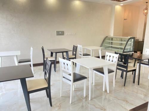 a dining room with white tables and chairs at Alhama Hotel Appartment in Khasab