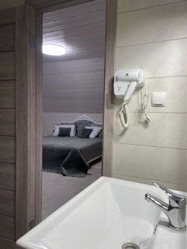 La salle de bains est pourvue d'un miroir au-dessus d'un lavabo et d'un lit. dans l'établissement Café Chalet Edelweiss Holiday Home, à Zbarazh
