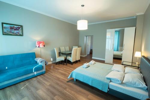 シュクラルスカ・ポレンバにあるSłoneczny Kątのベッドルーム(青いベッド1台、青いソファ付)