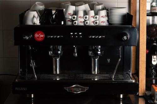 a black coffee machine with cups on a shelf at Harma Boutique Hotel in Hersonissos