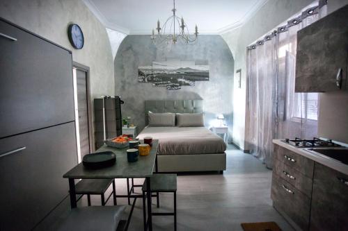 ein Schlafzimmer mit einem Bett und einem Tisch sowie eine Küche in der Unterkunft La Casetta di Lulù in Neapel