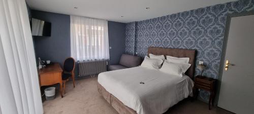 a hotel room with a bed and a desk and a bed sidx sidx at Hotel Meurice in Calais