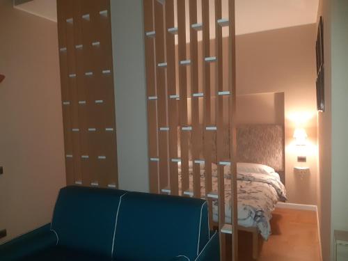 1 dormitorio con 1 cama y 1 silla azul en Catenica, en Milán