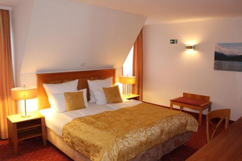 Habitación de hotel con 1 cama grande y 2 lámparas en myMINGA4 - Hotel & serviced Apartments, en Múnich