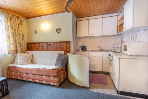 a small kitchen with a couch and a microwave at Haus Suban in Längenfeld