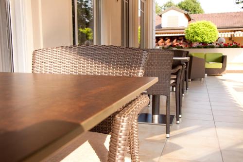 a wooden table and chairs in a restaurant at Chalét zum Kurfürst in Oberschleißheim