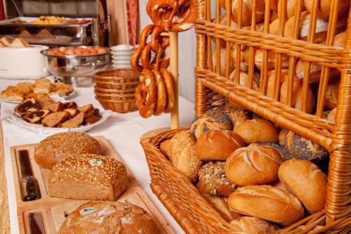 a table topped with baskets of bread and pastries at Chalét zum Kurfürst in Oberschleißheim