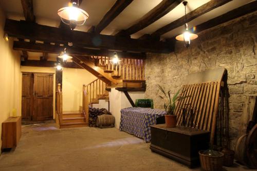 Habitación con pared de piedra y escalera con luces. en Casa Rural Ardantzena, en Ardaiz