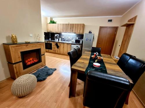 a living room with a wooden table and a fireplace at Borovets Sequoia2 luxury Apartment in Borovets