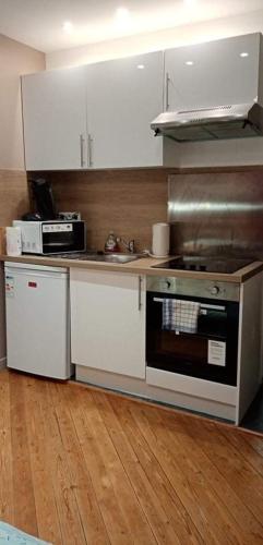 a kitchen with white cabinets and a stove top oven at Rouen hyper centre ville Palais de Justice in Rouen
