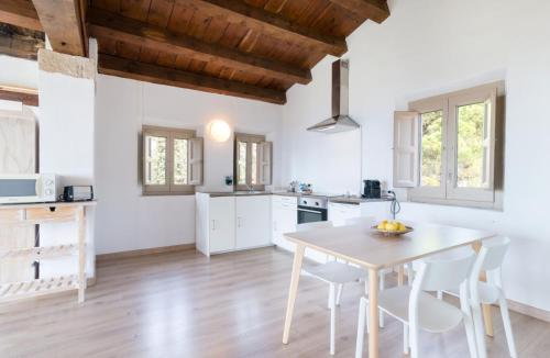 a kitchen and dining room with a table and chairs at Mas Ses Vinyes - Adults Only in Begur