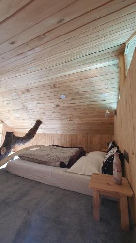 a bedroom with a bed in a wooden room at LITTLE WOOD TREEHOUSE in Jibhi