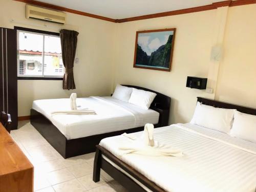 a hotel room with two beds and a window at Golden Bee PhiPhi in Phi Phi Don