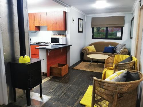 a small living room with a kitchen and a couch at @Baramee in Underberg