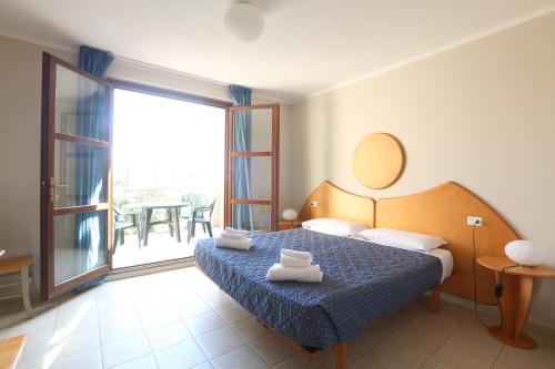 a hotel room with a bed and a balcony at Cosmopolitan Golf & Beach Resort in Tirrenia