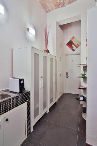 una cucina con mobili bianchi e un lavandino di Rome Place a Roma