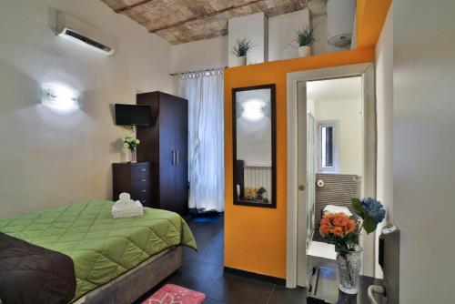 una camera da letto con un letto verde e uno specchio di Rome Place a Roma