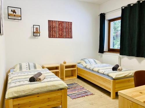 Zimmer mit 2 Betten und einem Fenster in der Unterkunft Family House Apartma in Mozirje