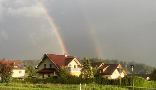 a rainbow in the sky over some houses at Ferienwohnung Wittenburg in Hermagor